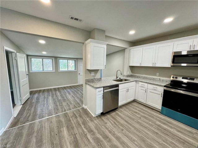 kitchen featuring stainless steel appliances, white cabinetry, light hardwood / wood-style floors, and sink