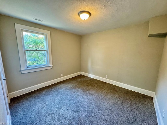 carpeted spare room featuring a textured ceiling