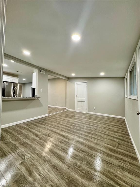 interior space with stainless steel fridge and dark wood-type flooring