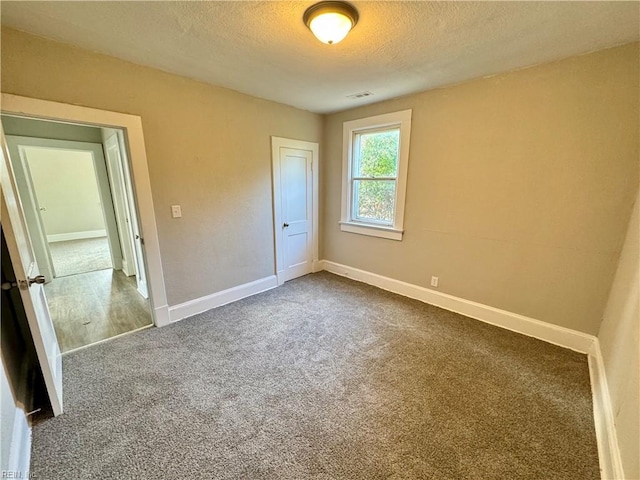 unfurnished bedroom featuring carpet flooring and a textured ceiling