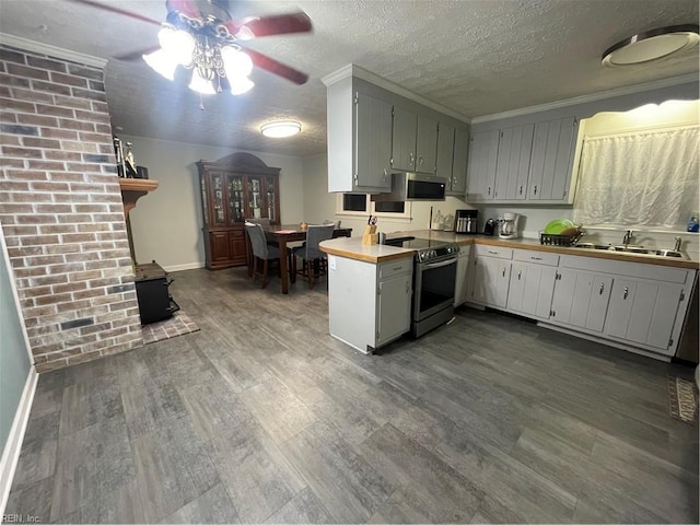 kitchen with sink, stainless steel appliances, kitchen peninsula, wood-type flooring, and a textured ceiling