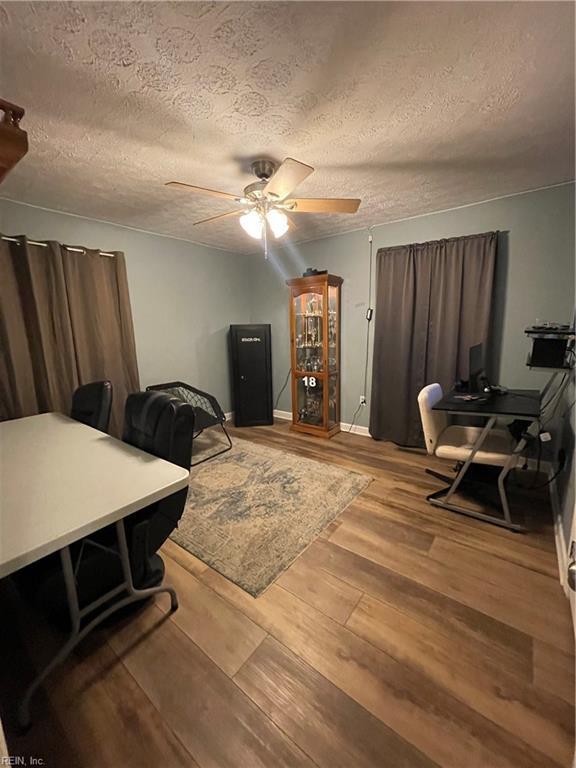 home office featuring ceiling fan, light hardwood / wood-style floors, and a textured ceiling