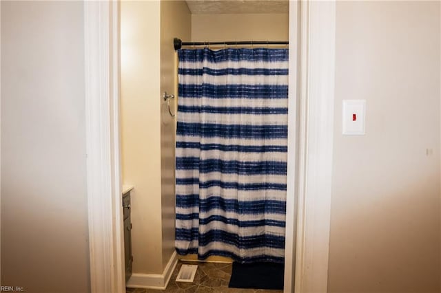 bathroom featuring tile patterned flooring, vanity, and walk in shower