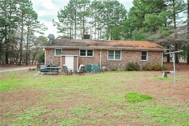 back of property with a yard and central air condition unit