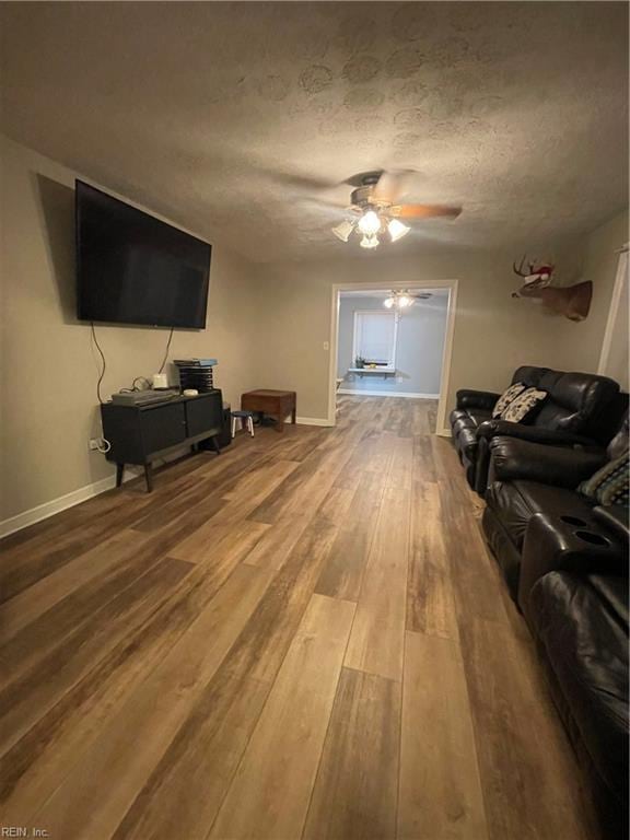 living room featuring hardwood / wood-style floors, a textured ceiling, and ceiling fan