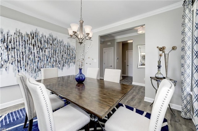 dining space featuring dark hardwood / wood-style flooring, an inviting chandelier, and ornamental molding