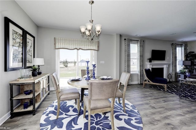 dining room with a wealth of natural light, hardwood / wood-style floors, and a notable chandelier