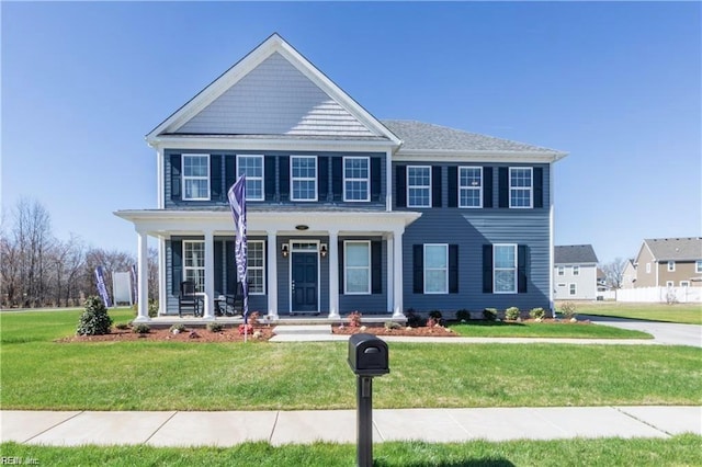 colonial-style house with a porch and a front yard