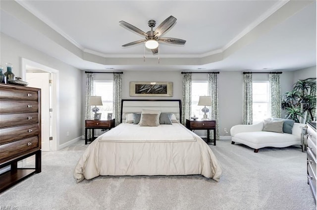 carpeted bedroom featuring a tray ceiling, multiple windows, and ceiling fan