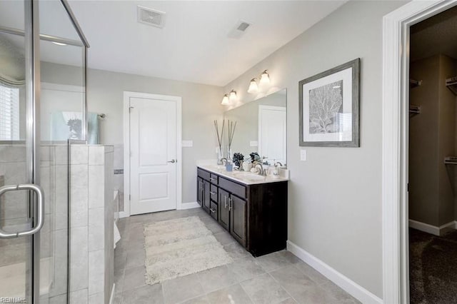 bathroom with tile patterned floors, vanity, and a shower with door