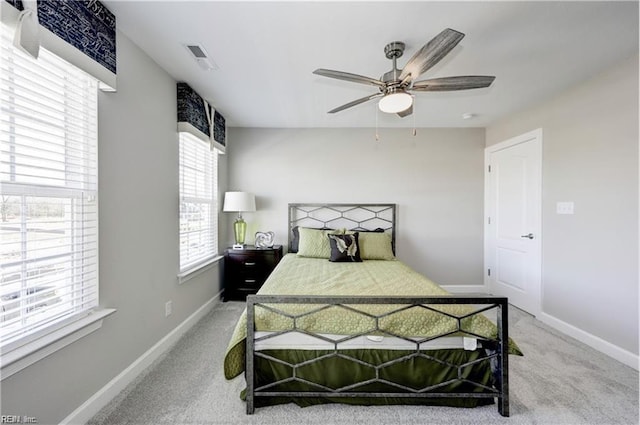 carpeted bedroom featuring multiple windows and ceiling fan