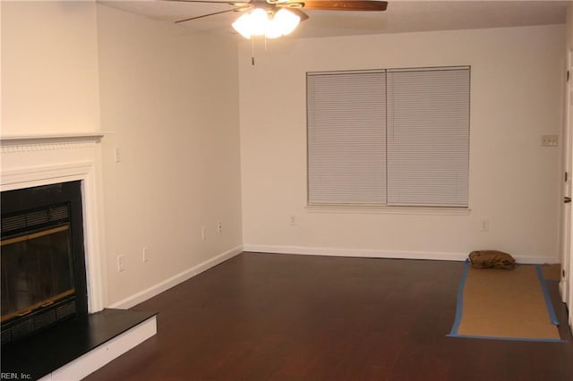 unfurnished living room featuring ceiling fan and dark wood-type flooring