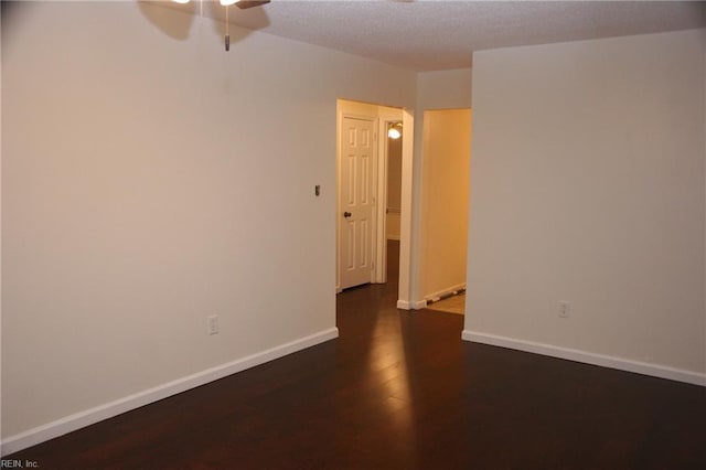 spare room with ceiling fan and dark hardwood / wood-style flooring