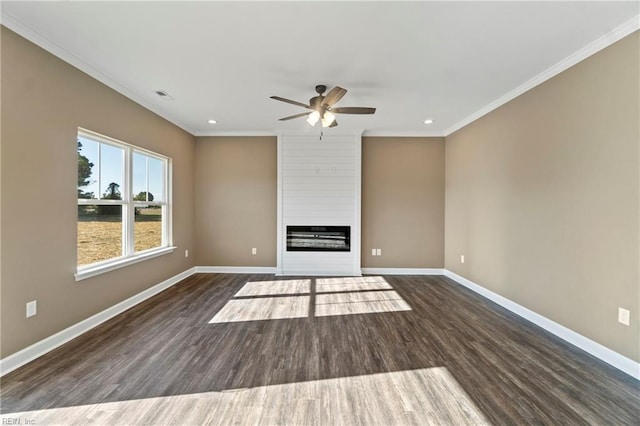 unfurnished living room with crown molding, a large fireplace, and dark hardwood / wood-style floors