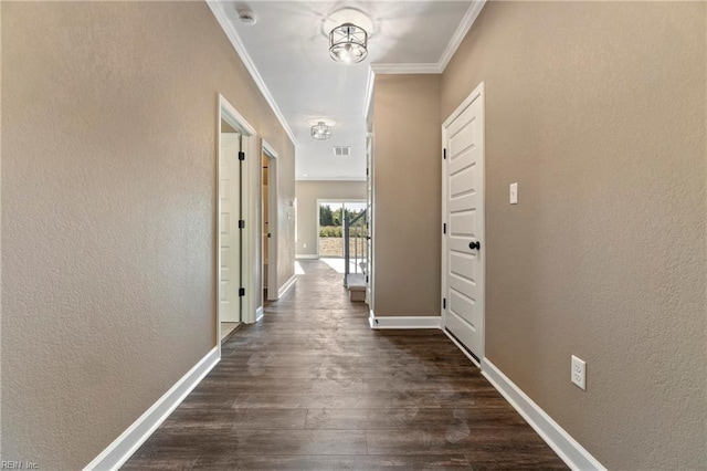 hall with an inviting chandelier, crown molding, and dark wood-type flooring