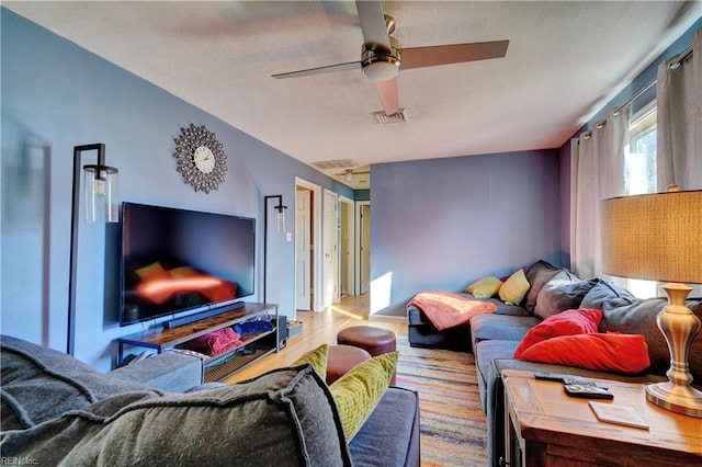 living room with light hardwood / wood-style flooring and ceiling fan