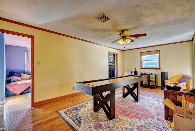 game room with ceiling fan, crown molding, and light hardwood / wood-style flooring