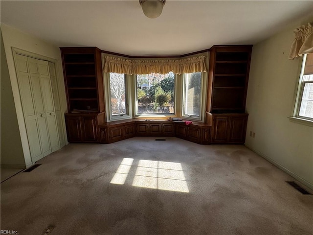 miscellaneous room featuring light colored carpet