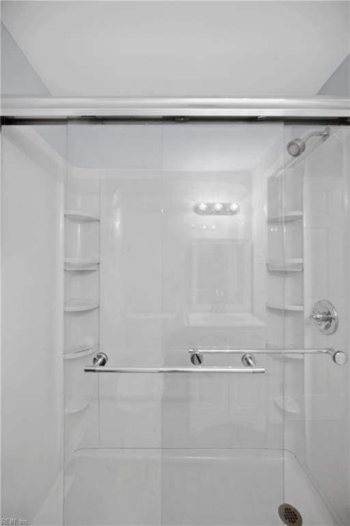 bathroom featuring a shower with shower door