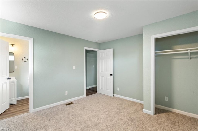 unfurnished bedroom featuring light carpet and a closet