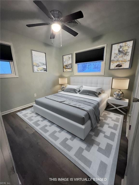 bedroom with a ceiling fan, visible vents, wood finished floors, and baseboards