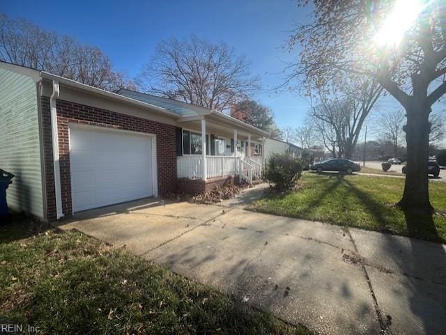 view of home's exterior featuring brick siding, covered porch, an attached garage, and concrete driveway