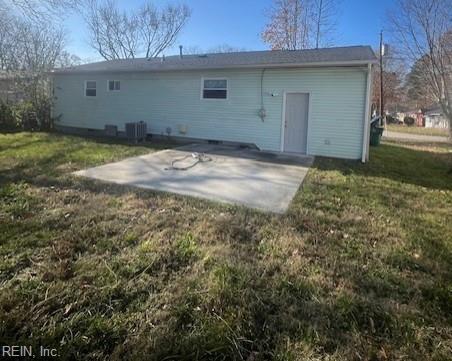 rear view of property with a yard, central AC unit, and a patio area