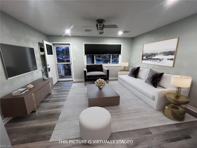 living room featuring ceiling fan and dark hardwood / wood-style floors