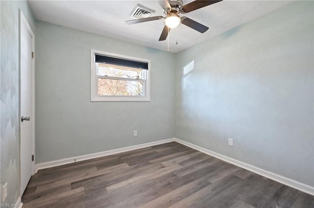 unfurnished room with visible vents, baseboards, dark wood-type flooring, and a ceiling fan