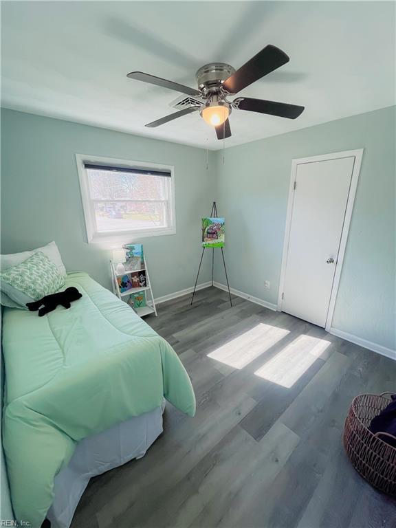 bedroom with a ceiling fan, baseboards, and wood finished floors