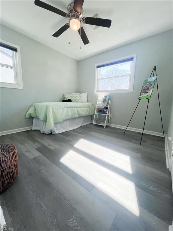 unfurnished bedroom featuring multiple windows, baseboards, and wood finished floors