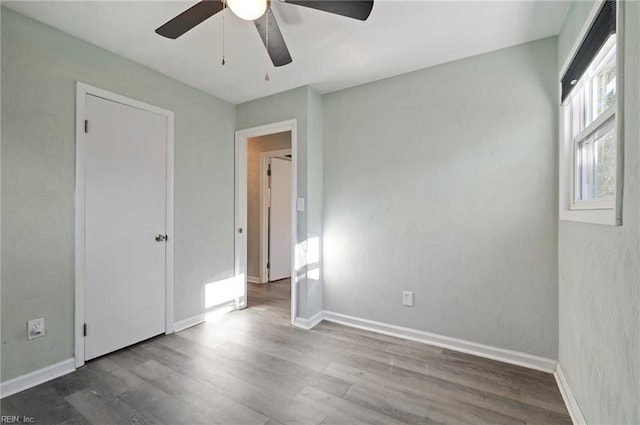 unfurnished room with ceiling fan, baseboards, and wood finished floors