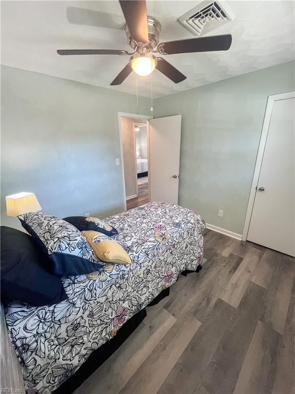 bedroom featuring visible vents, baseboards, wood finished floors, and a ceiling fan