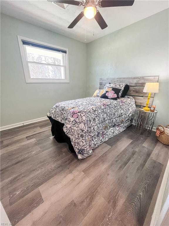 bedroom featuring a ceiling fan, wood finished floors, and baseboards