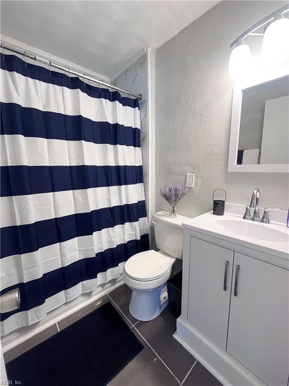 full bathroom featuring curtained shower, toilet, vanity, and tile patterned flooring