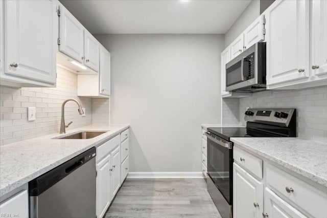 kitchen with white cabinets, light hardwood / wood-style floors, sink, and appliances with stainless steel finishes