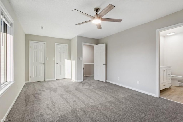 unfurnished bedroom featuring connected bathroom, ceiling fan, and light carpet