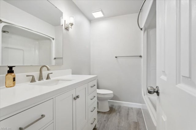 full bathroom with toilet, vanity, wood-type flooring, and washtub / shower combination