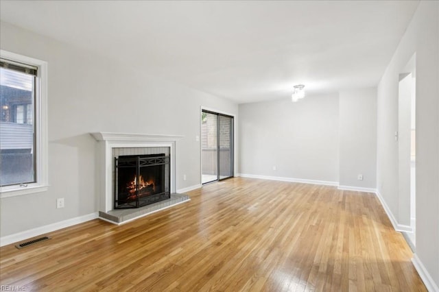 unfurnished living room featuring a wealth of natural light and light hardwood / wood-style floors