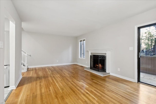 unfurnished living room with a healthy amount of sunlight and light hardwood / wood-style flooring