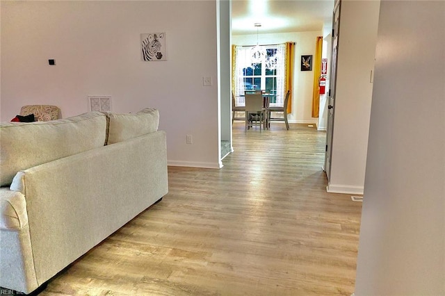 living room featuring light hardwood / wood-style floors and an inviting chandelier