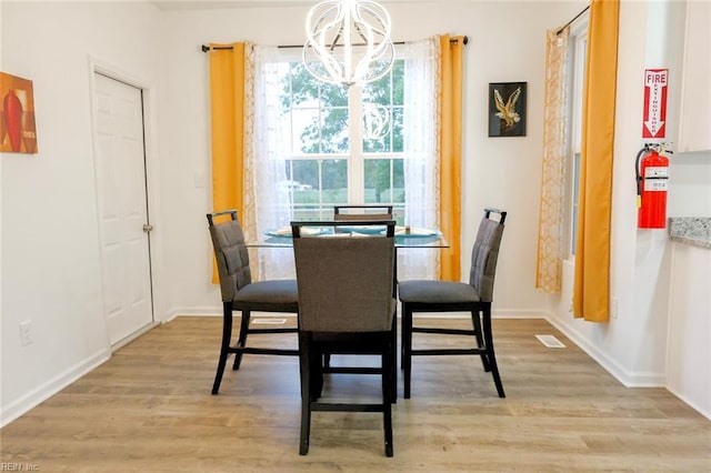 dining space with a chandelier and light wood-type flooring