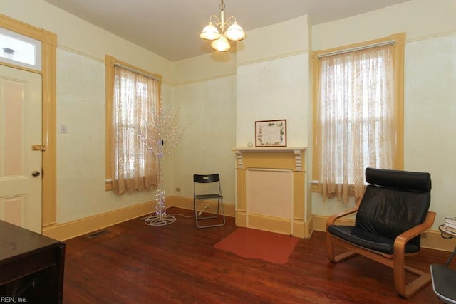 living area with an inviting chandelier, baseboards, and wood finished floors