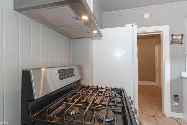 kitchen with light tile patterned floors, gas stove, and custom range hood