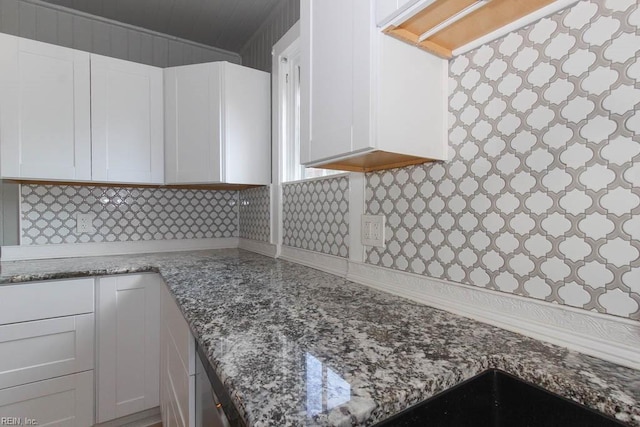 room details with stone counters, tasteful backsplash, and white cabinetry