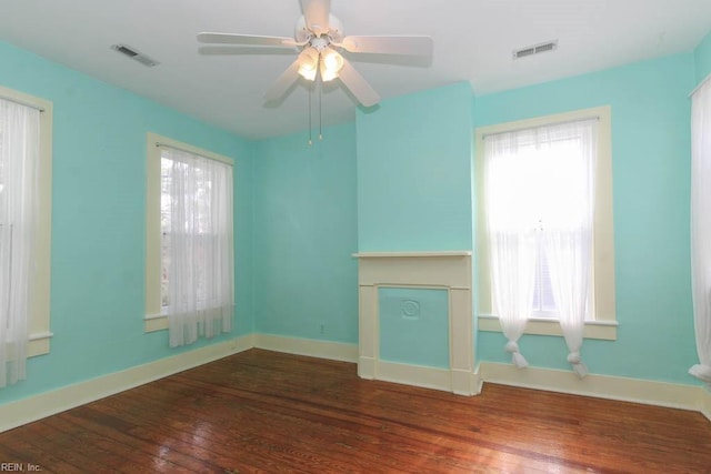 unfurnished living room featuring hardwood / wood-style floors, visible vents, and a healthy amount of sunlight