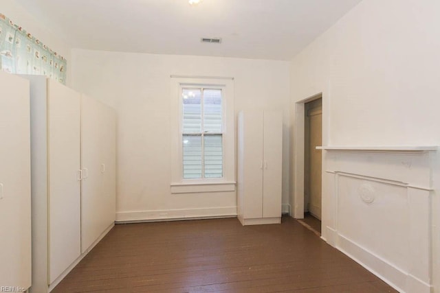 spare room with dark wood-style floors and visible vents