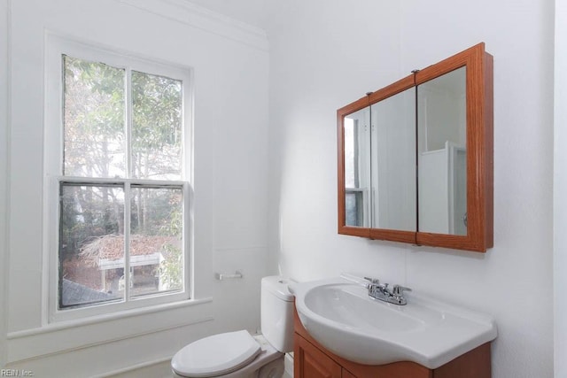 bathroom featuring a healthy amount of sunlight, vanity, and toilet