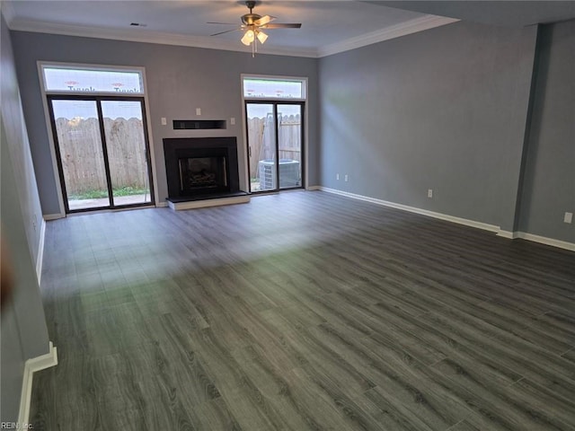 unfurnished living room with crown molding, plenty of natural light, dark wood-type flooring, and ceiling fan