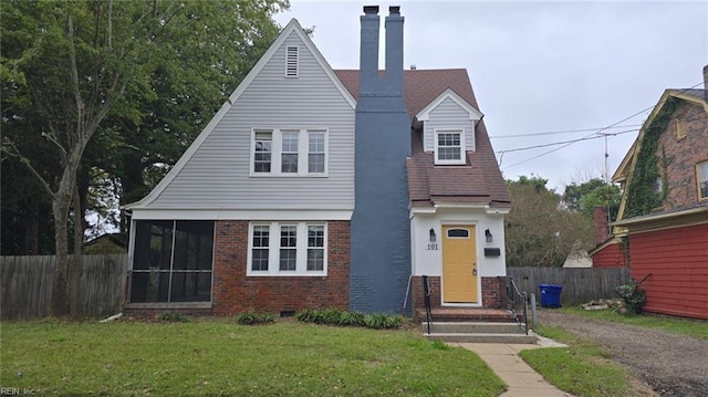 view of front of home featuring a front yard and a sunroom